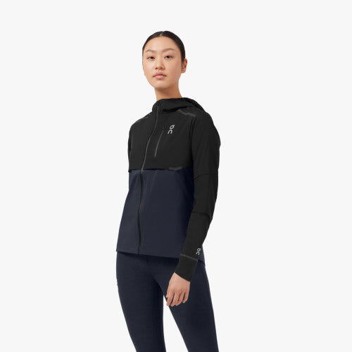 Front view of a model wearing the Women's Weather Jacket from ON in Black/Navy
