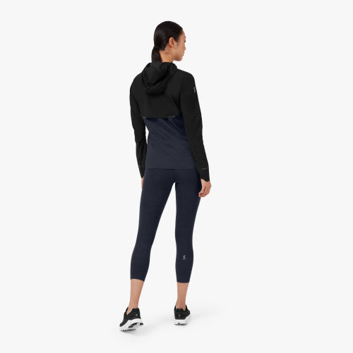 Back view of a model wearing the Women's Weather Jacket from ON in Black/Navy