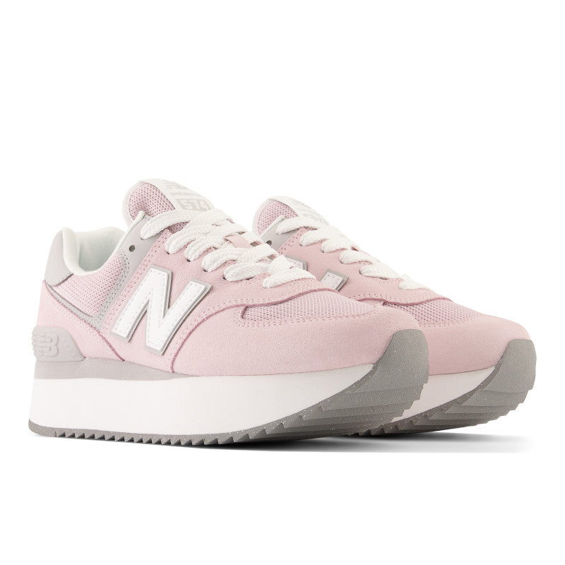 Front angle view of the Women's 574+ lifestyle shoe by New Balance in the color Stone Pink