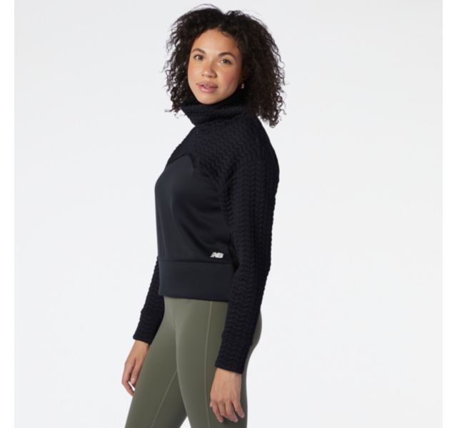 Side view of a model wearing the Women's Heat Loft Pullover by New Balance in Black